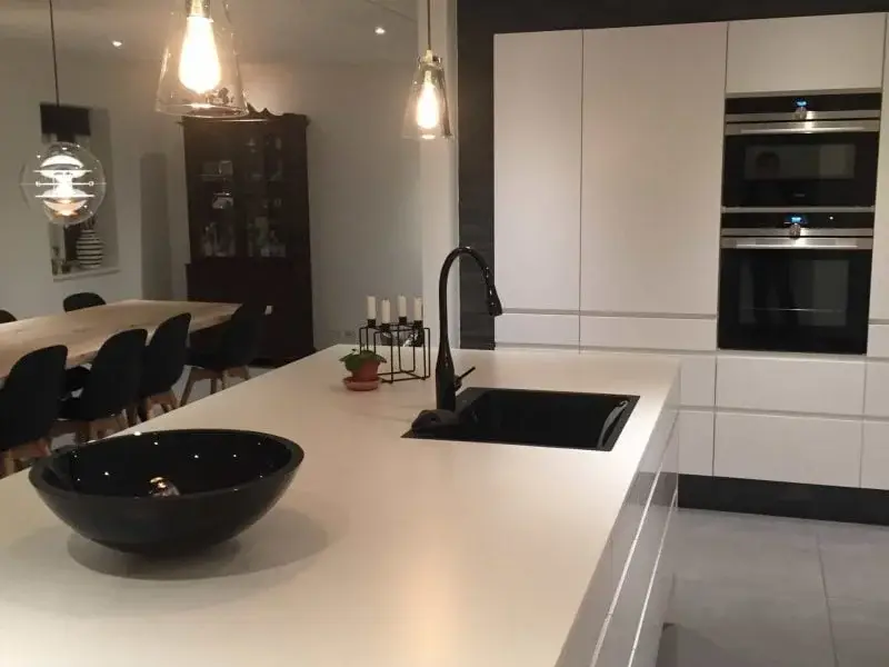 Moderne køkken med hvide skabe og spiseområde