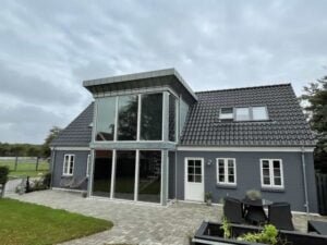 Moderne gråt hus med store vinduer og terrasse