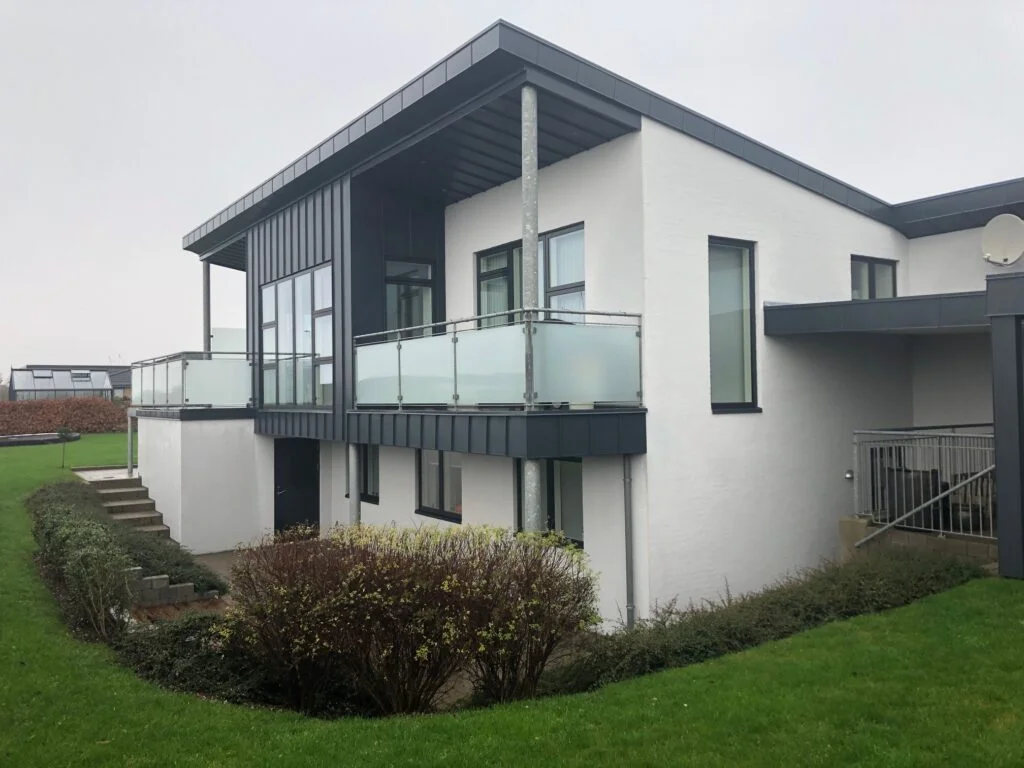 Moderne hvid villa med altaner og have