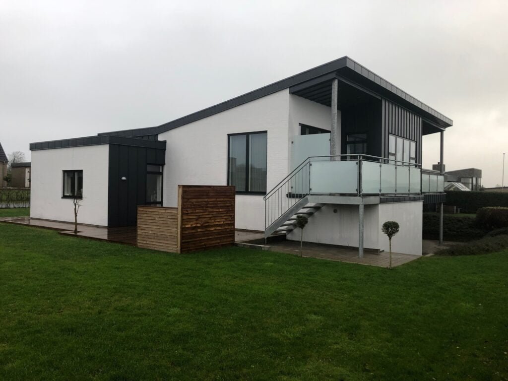 Moderne hvid villa med altan og græsplæne