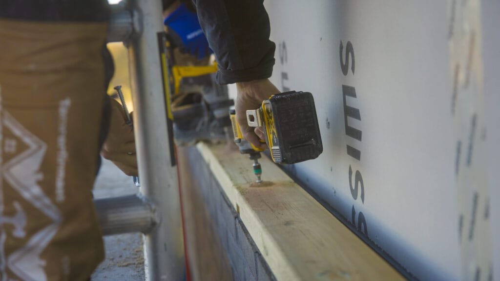 Håndværker bruger boremaskine til træbyggeri